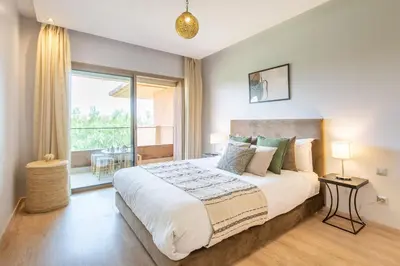 a bedroom with a large bed and a large window at Escale de Charme - Prestigia Golf - Vue piscine in Marrakech