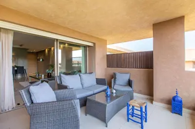 a patio with a couch and chairs and a table at Escale de Charme - Prestigia Golf - Vue piscine in Marrakech