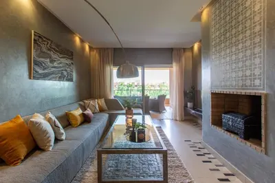 a living room with a couch and a fireplace at Escale de Charme - Prestigia Golf - Vue piscine in Marrakech