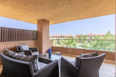 a living room with a table and chairs and a large window at Escale de Charme - Prestigia Golf - Vue piscine in Marrakech