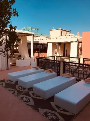 a row of white mattresses sitting on a patio at riad anrich in Marrakech