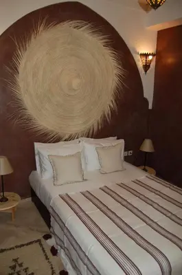 a bedroom with a large bed with a wooden headboard at riad anrich in Marrakech