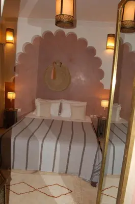 a bedroom with a large bed with a mirror at riad anrich in Marrakech
