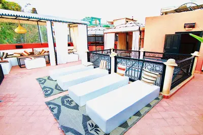a row of white benches sitting on a balcony at riad anrich in Marrakech
