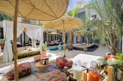a resort with a pool and a patio with umbrellas at Riad Mazarin des gourmets in Marrakech