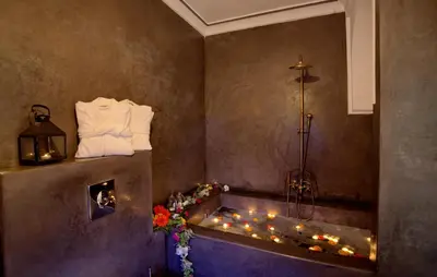 a bathroom with a bathtub with candles and a heater at Riad Mazarin des gourmets in Marrakech