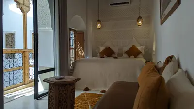 a bedroom with a bed and a couch and a window at Riad Dar Eternity in Marrakech