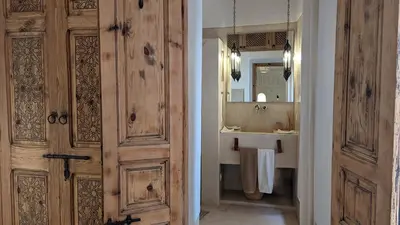 a bathroom with a wooden door and a sink at Riad Dar Eternity in Marrakech
