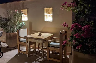 a wooden table and chairs in a room with flowers at Riad Dar Eternity in Marrakech