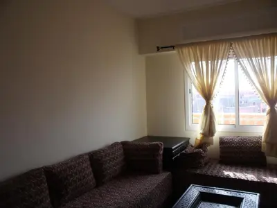 a living room with a couch and a window at Appartement Aïda in Marrakech