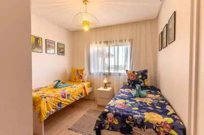 a bedroom with two beds and a window at Cozy Golf Apartment Wifi 4k-TV Netflix in Marrakech