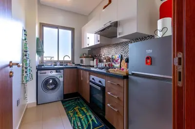 a kitchen with a washing machine and a washer at Cozy Golf Apartment Wifi 4k-TV Netflix in Marrakech