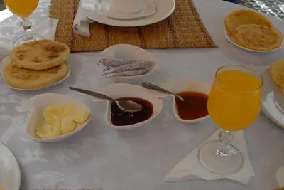 a table with plates of food and a glass of orange juice at Riad Hôtel Belleville Marrakech in Marrakech