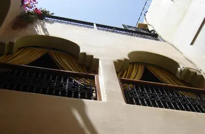 a building with a balcony with a window at Riad Hôtel Belleville Marrakech in Marrakech
