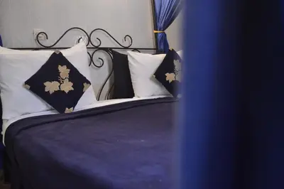 a bed with black and white pillows on it at Riad Hôtel Belleville Marrakech in Marrakech