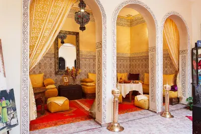 a living room with a table and chairs in a room at Riad La Kahana in Marrakech