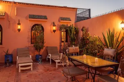 a patio with a table and chairs in a courtyard at Riad La Kahana in Marrakech
