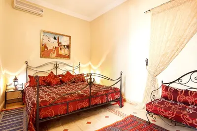 a bedroom with a red bed and a window at Riad La Kahana in Marrakech