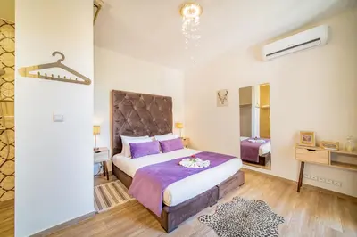 a bedroom with a large bed with purple pillows at Villa White High-Standing - Breakfast in Marrakech
