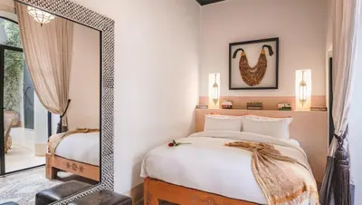 a bedroom with a bed and a mirror at Dar Assiya in Marrakech