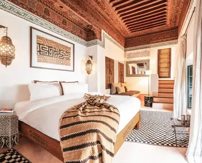 a bedroom with a large bed with a wooden ceiling at Dar Assiya in Marrakech