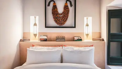 a bed with two white pillows and a picture on the wall at Dar Assiya in Marrakech
