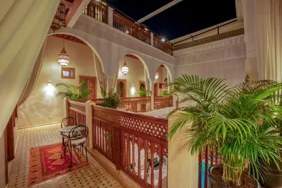 a room with a balcony with a table and a plant at Riad Janate & SPA in Marrakech