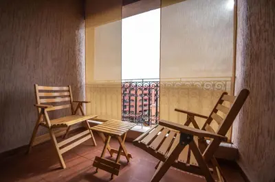 two chairs and a table in a room with a window at Hôtel Ibn Batouta in Marrakech