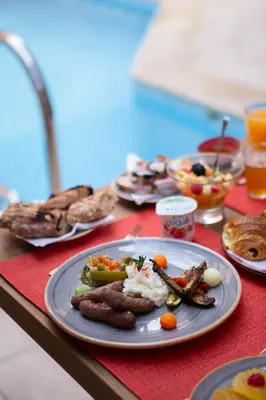 a table with a plate of food on a red napkin at Hôtel Ibn Batouta in Marrakech