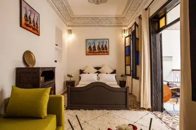 a bedroom with a bed and a yellow couch at Riad 111 & Spa in Marrakech