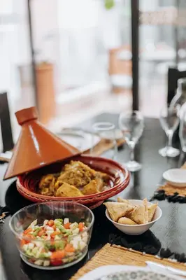a table topped with a bowl of food and chips at Riad ANYSSA in Marrakech