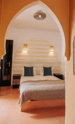 a bedroom with a large bed in an arch way at Riad ANYSSA in Marrakech