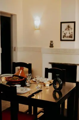 a dining room table with plates and glasses on it at Riad ANYSSA in Marrakech
