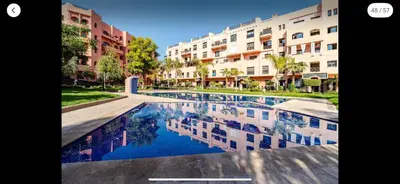 a large swimming pool in front of a building at Appart Kech Village in Marrakech