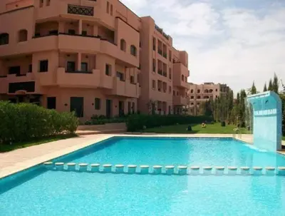 a large swimming pool in front of a building at Appart Kech Village in Marrakech