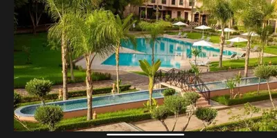 an overhead view of a swimming pool with palm trees at Appart Kech Village in Marrakech