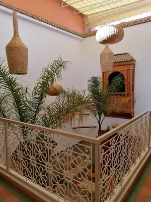 a room with plants on a balcony with a table at DAR MAR'OUKA , Maison d'hôtes in Marrakech