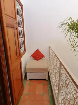 a stairway with a bench next to a door at DAR MAR'OUKA , Maison d'hôtes in Marrakech