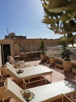 a patio with tables and chairs on a roof at DAR MAR'OUKA , Maison d'hôtes in Marrakech