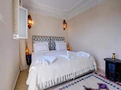 a bedroom with a large white bed with white sheets at Riad Princesse Du Désert & Spa in Marrakech