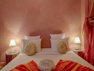 a bedroom with a bed with pillows on it at Riad Princesse Du Désert & Spa in Marrakech