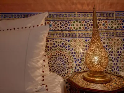 a bedroom with a bed and a vase on a table at Riad Princesse Du Désert & Spa in Marrakech