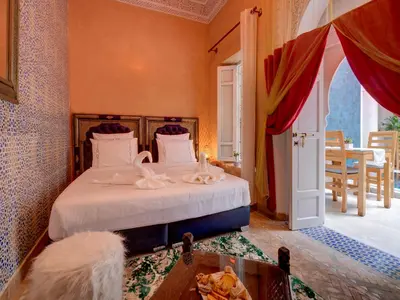 a bedroom with a bed with white sheets and a window at Riad Princesse Du Désert & Spa in Marrakech