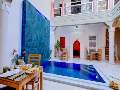 a pool in a living room with a table and chairs at Riad Princesse Du Désert & Spa in Marrakech