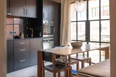 a kitchen with a wooden table and some chairs at Appartements Brummell Marrakech in Marrakech