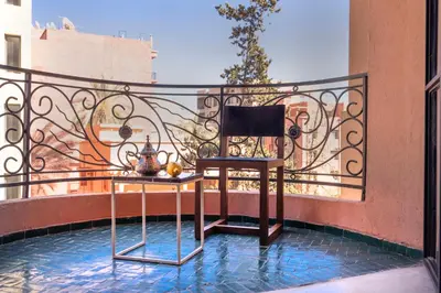 a chair and a table on a balcony at Appartements Brummell Marrakech in Marrakech
