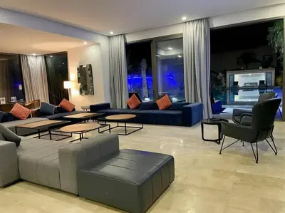 a living room with a couch and tables and chairs at Luxury Palm Villa in Marrakech