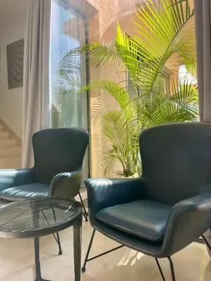 two chairs and a table in front of a window at Luxury Palm Villa in Marrakech
