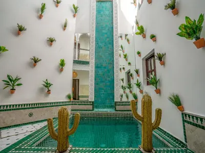 a pool in a building with cactus at Riad Art & Emotions in Marrakech