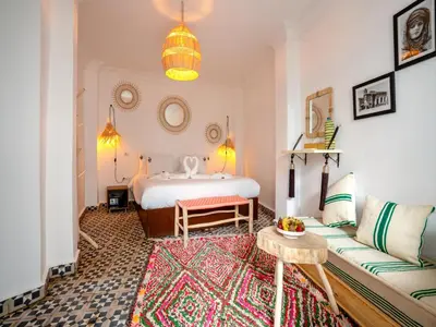 a living room with a bed and a couch at Riad Art & Emotions in Marrakech